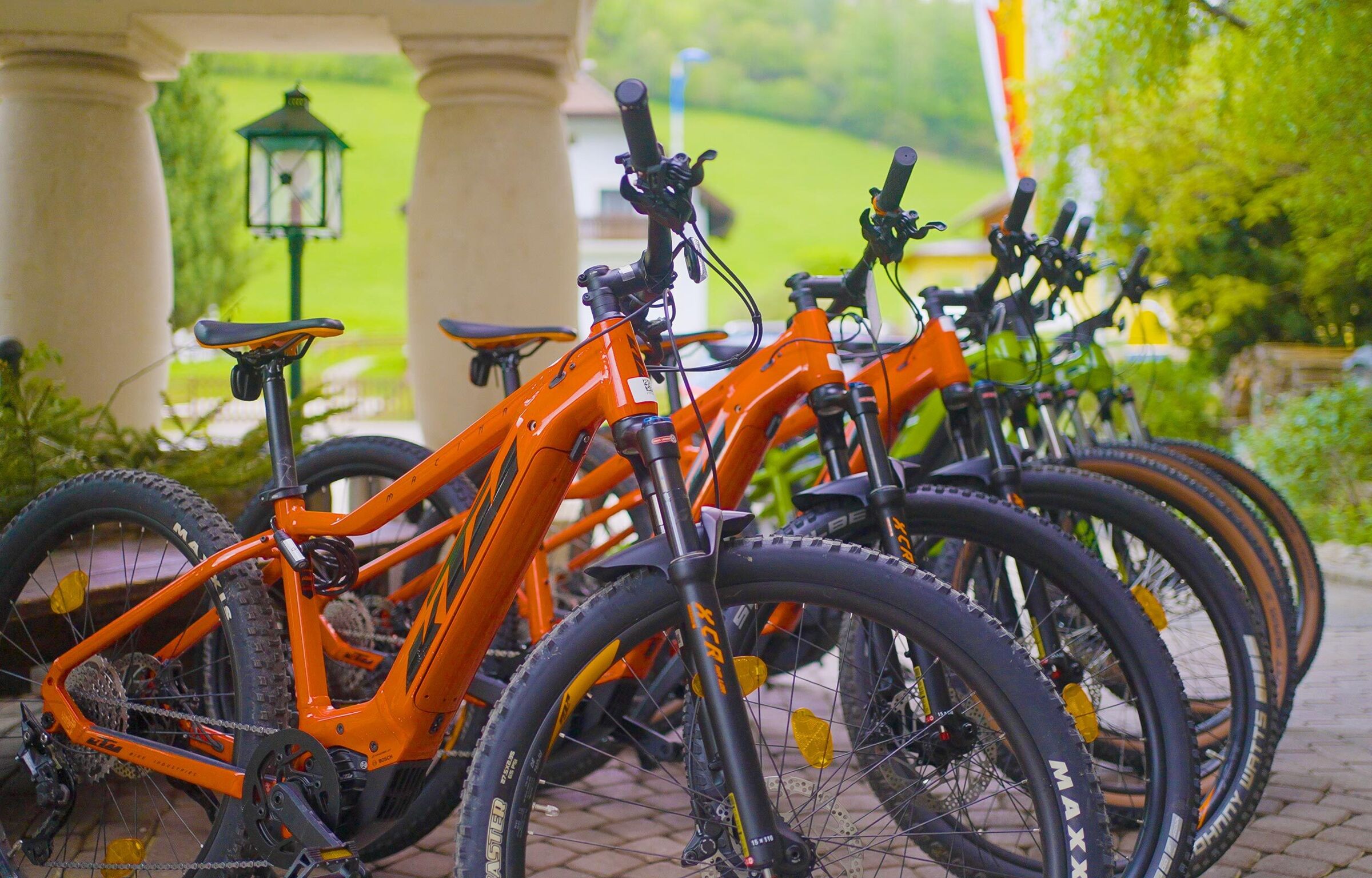 Einige orangene E-Mountainbikes stehen im Trattlerhof zum Verleih bereit.
