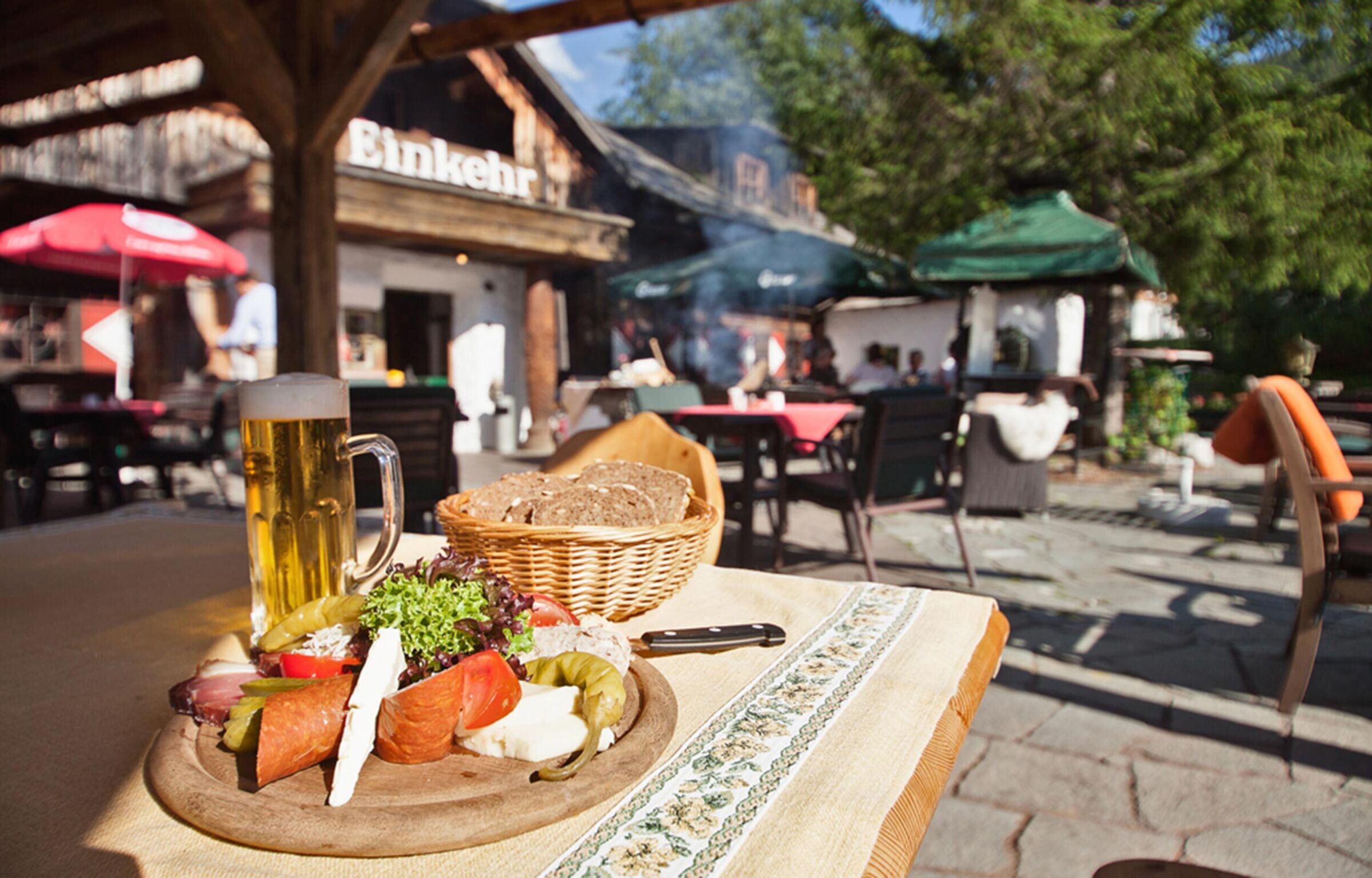 Brettljause und Bier steht auf einem Tisch in einem Gastgarten.