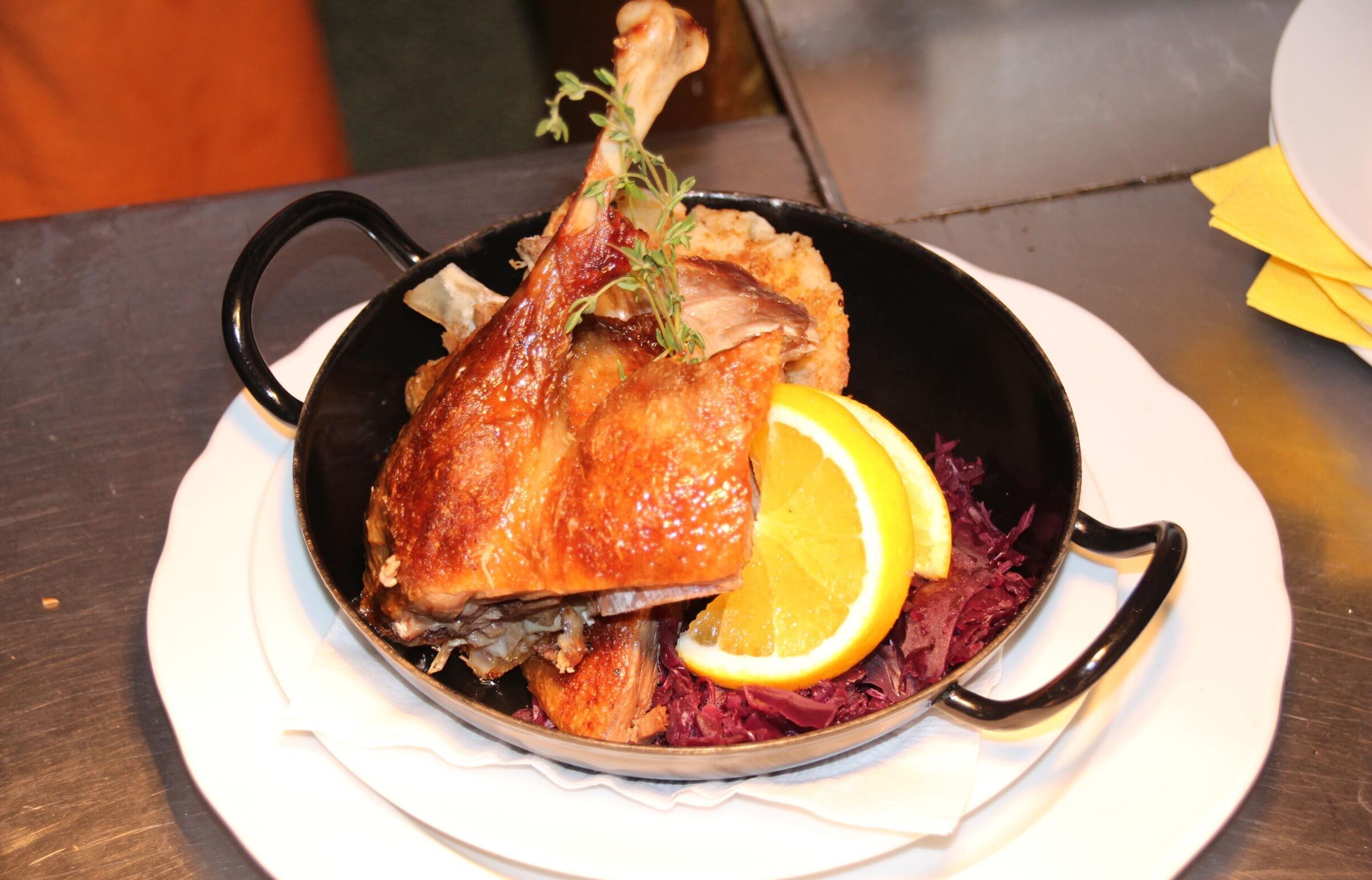 A leg of goose in a cast-iron pan with red cabbage