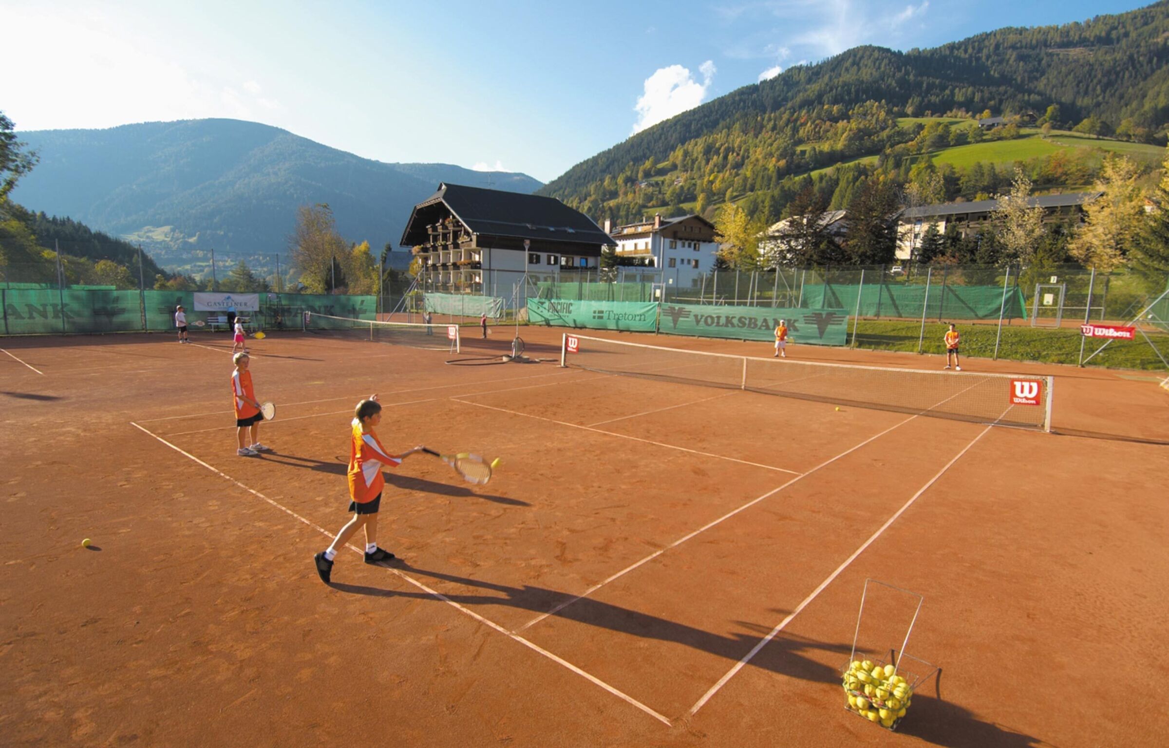 Children play doubles on a tennis court