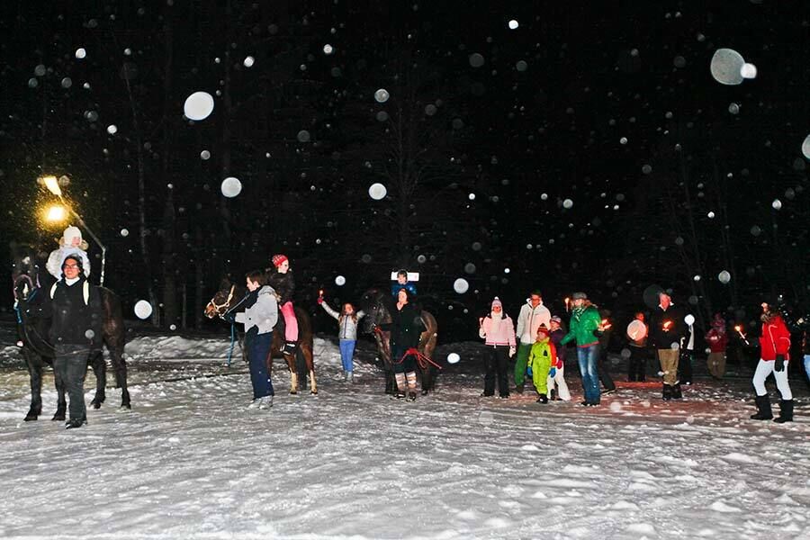 Many people walk with torches and horses through the night in Bad Kleinkirchheim