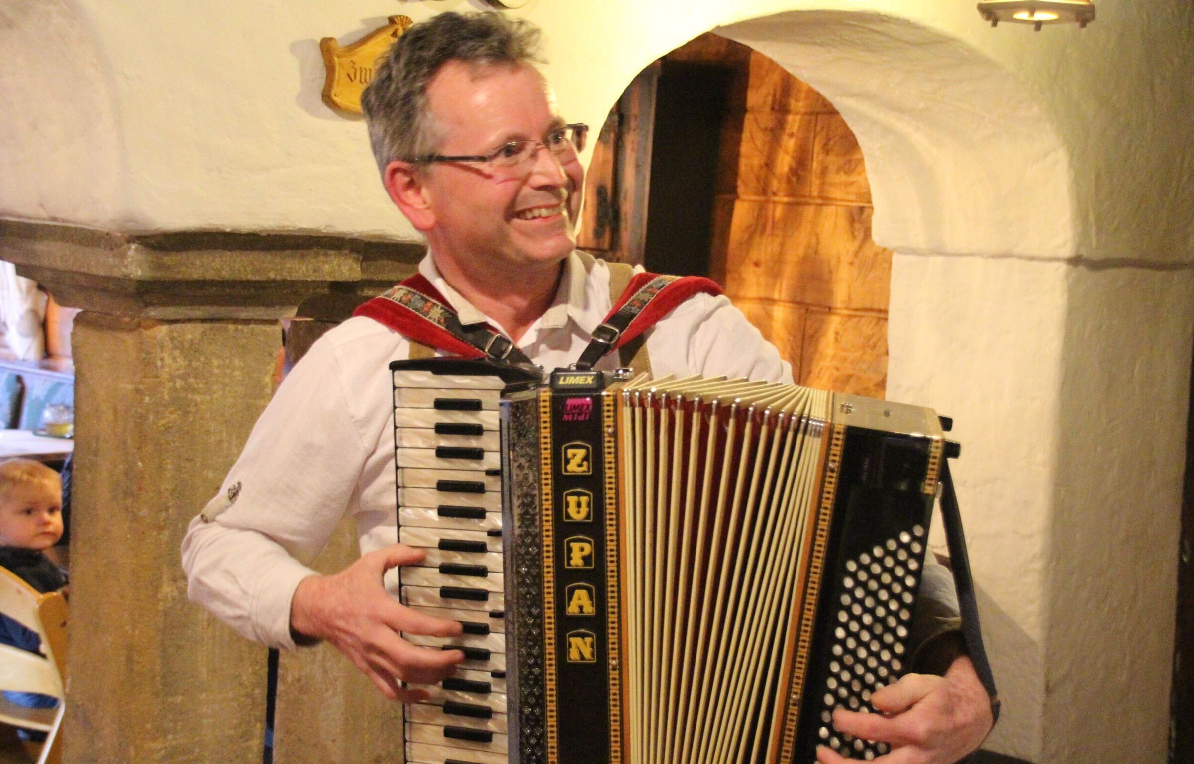 A man in traditional costume playing an accordion