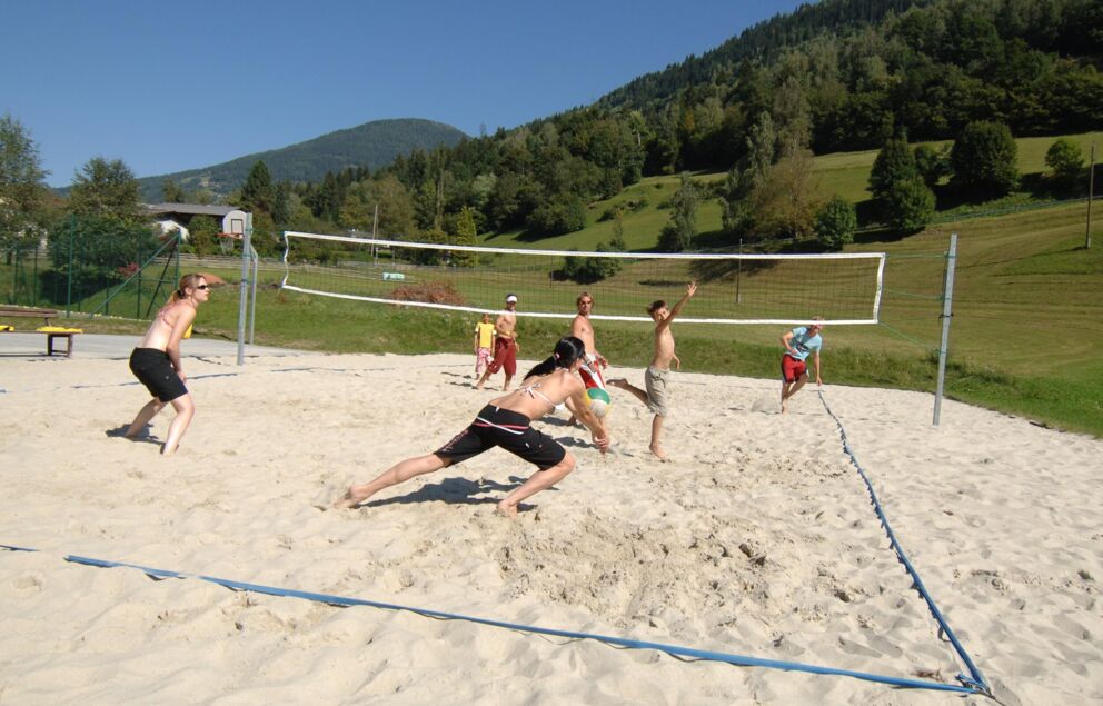 A group of young people play volleyball at the beach volleyball field in Bad Kleinkirchheim.