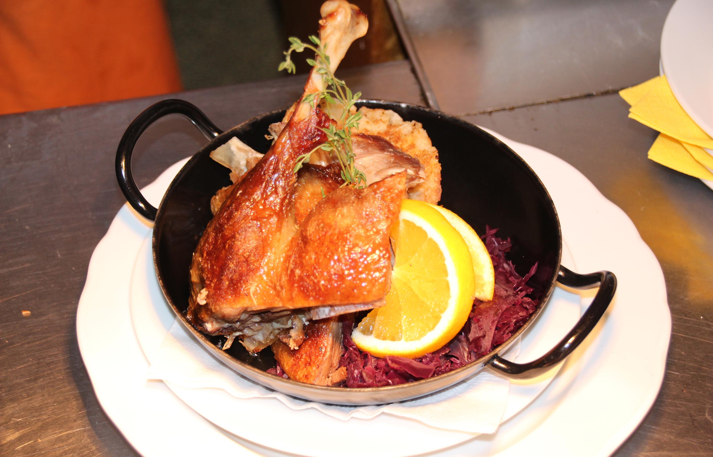 A leg of goose in a cast-iron pan with red cabbage